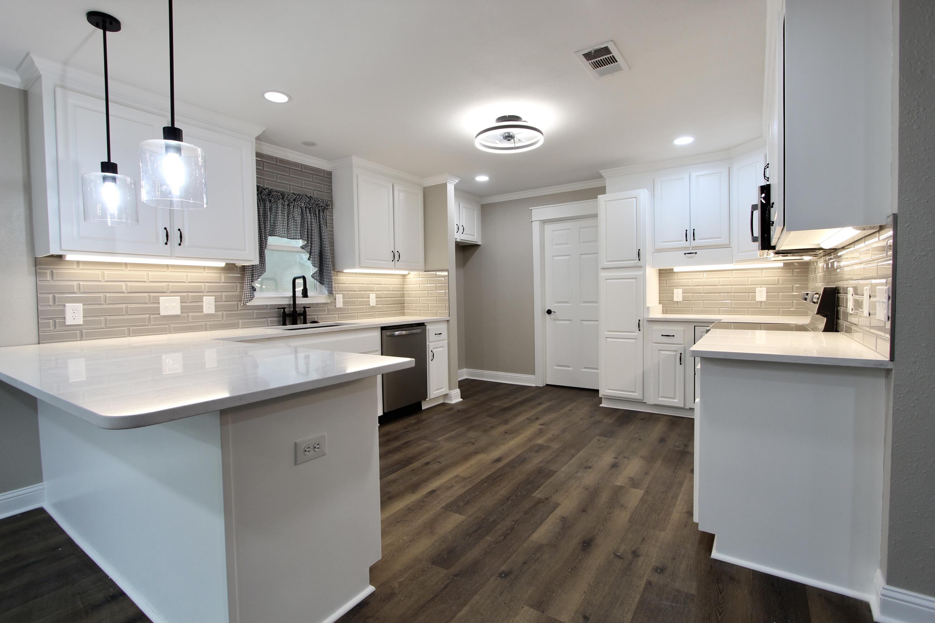 4052 Randi Road Crestview, FL 32539 - Photo 4 of 27 a kitchen with stainless steel appliances granite countertop a sink a stove a refrigerator and a oven with wooden floor