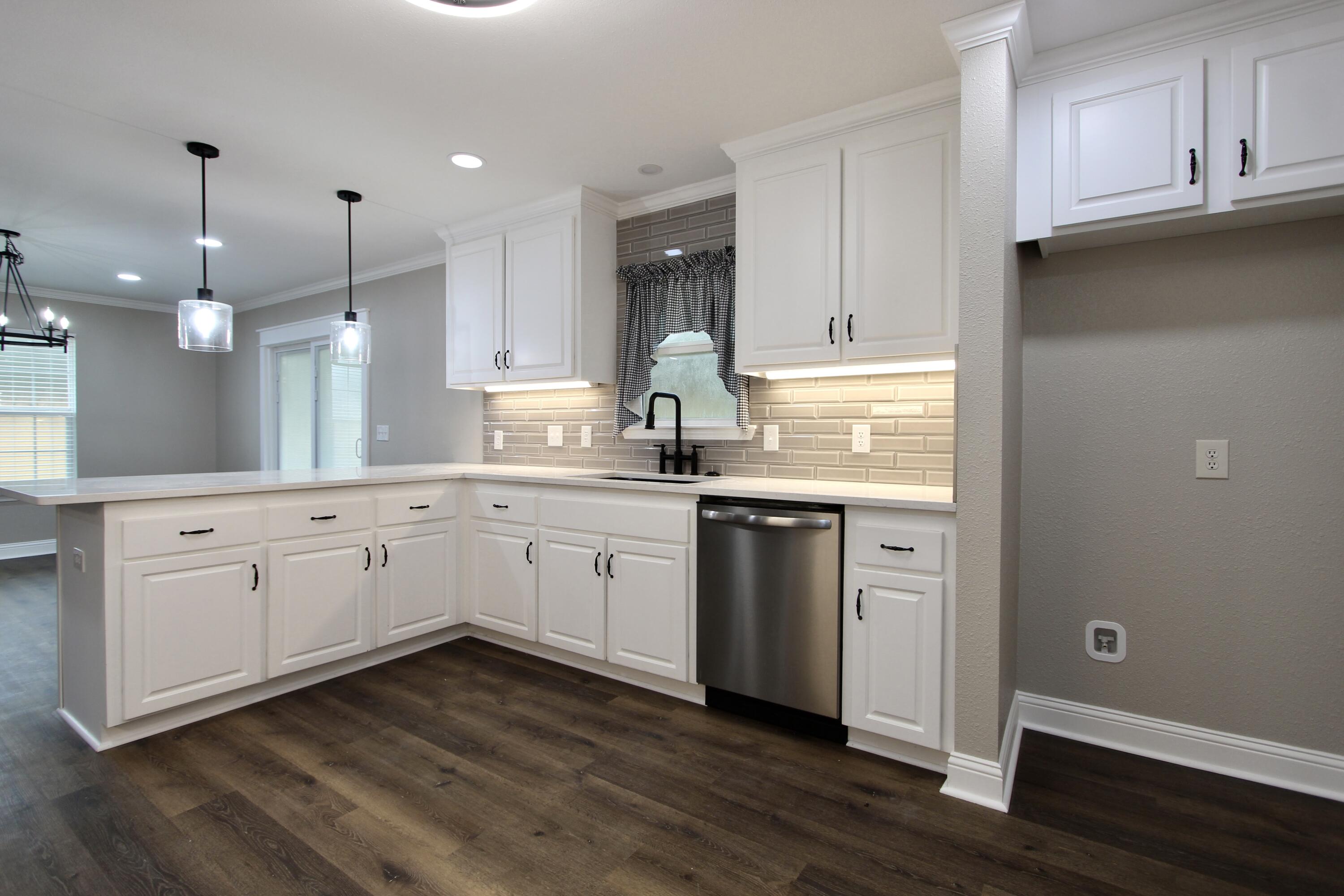 4052 Randi Road Crestview, FL 32539 - Photo 5 of 27 a kitchen with kitchen island granite countertop a sink cabinets and wooden floor