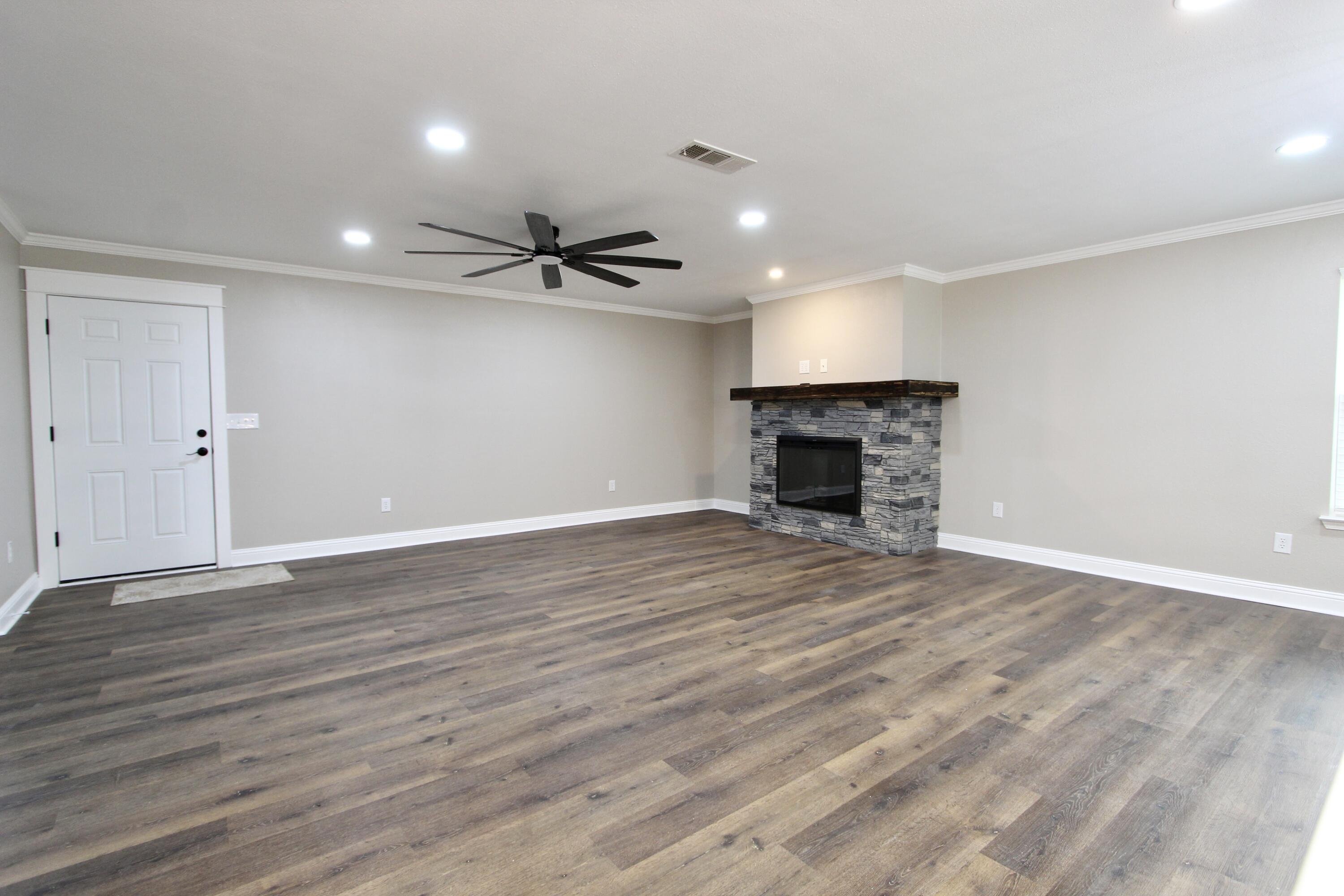 4052 Randi Road Crestview, FL 32539 - Photo 7 of 27 a view of an empty room with wooden floor fireplace and a window