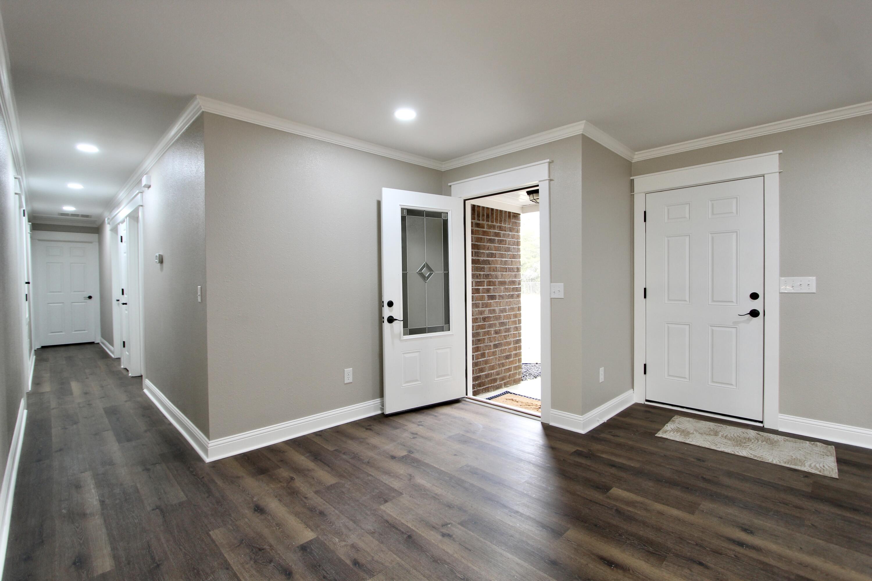 4052 Randi Road Crestview, FL 32539 - Photo 10 of 27 an empty room with wooden floor & windows and bathroom