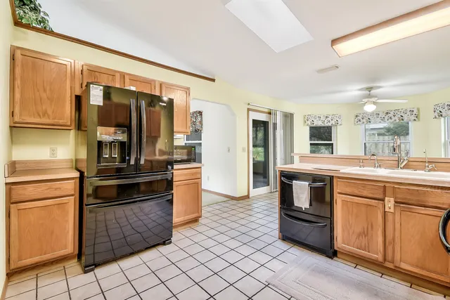 a kitchen with granite countertop a refrigerator and a stove top oven