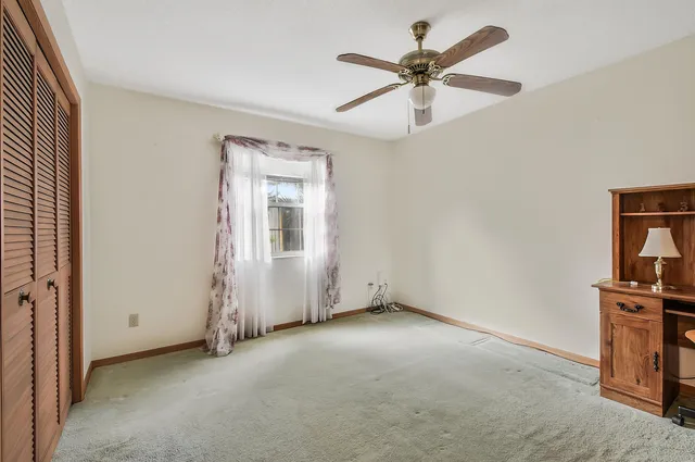an empty room with closet and fan