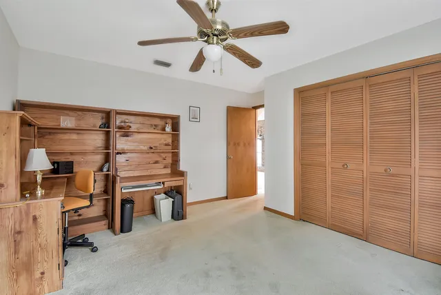 wooden view of room with walk in closet and window