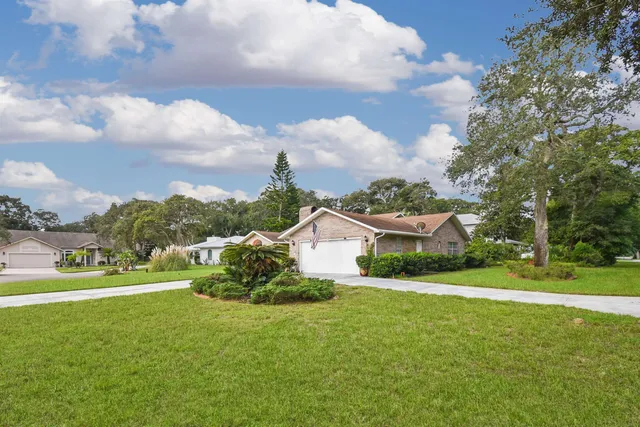 a view of a house with a big yard and potted plants