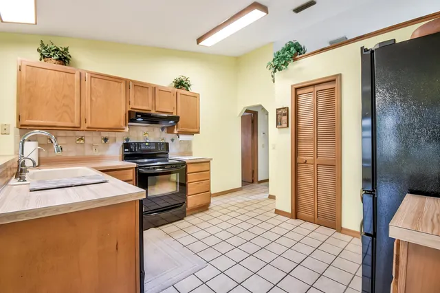 a kitchen with stainless steel appliances granite countertop a refrigerator sink and stove