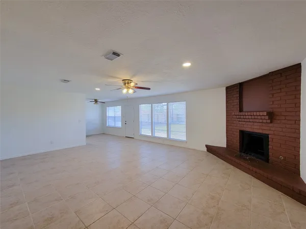 an empty room with a fireplace and window