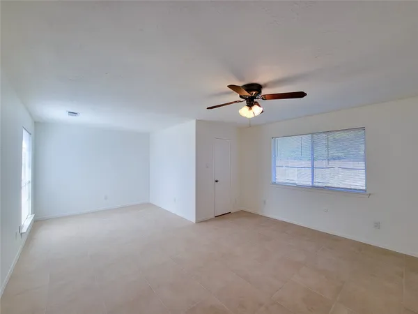 a view of an empty room with a ceiling fan