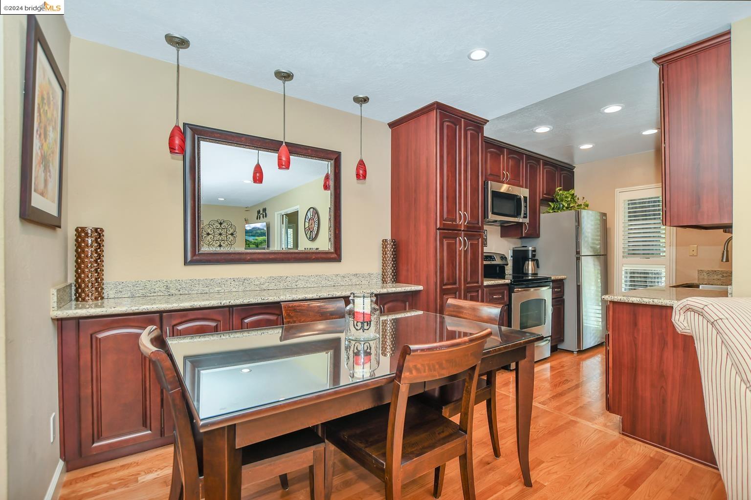 a kitchen with stainless steel appliances granite countertop a stove a sink and a refrigerator with wooden floor