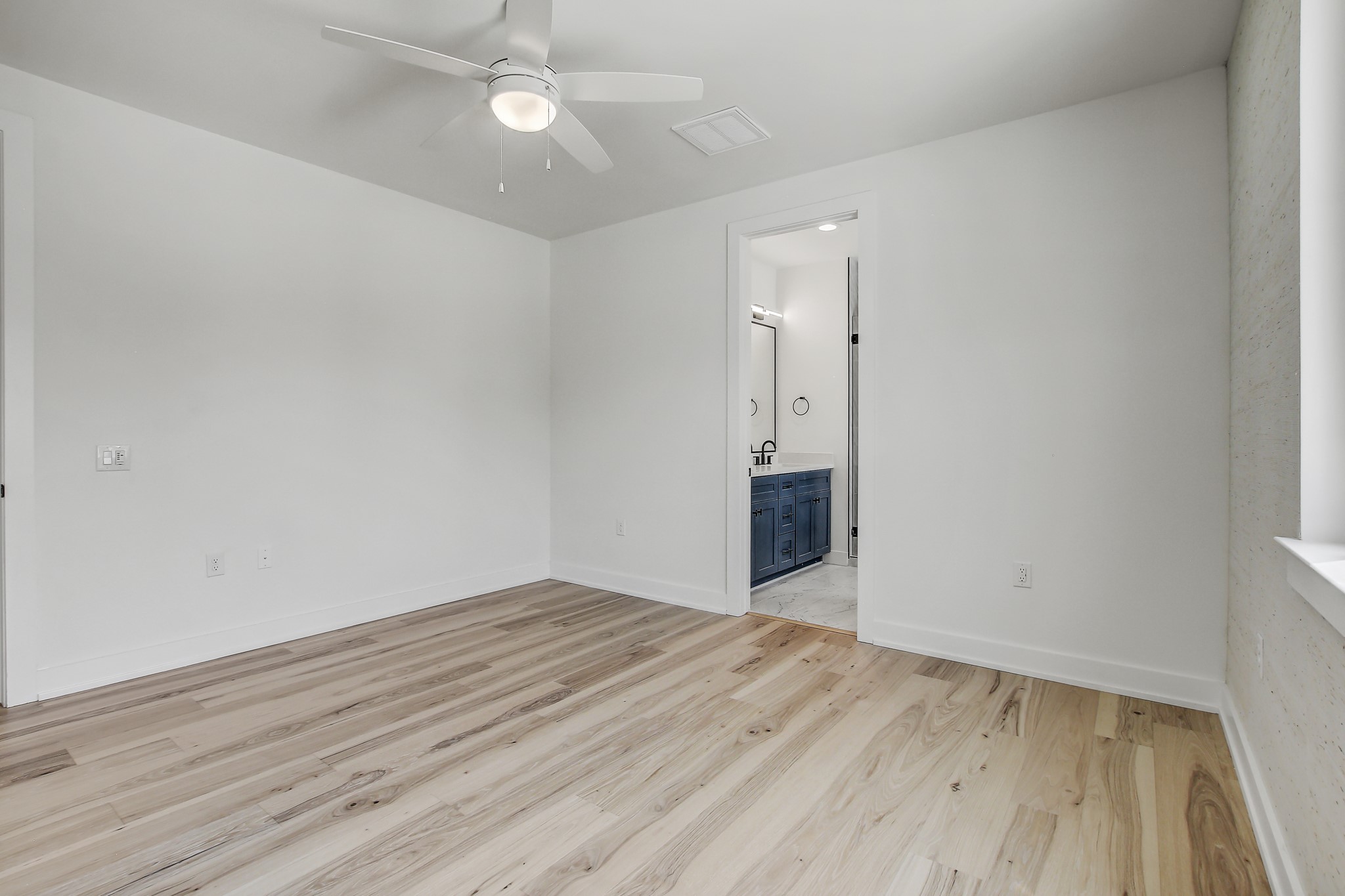 4127 East 12th Street, Unit 4 Austin, TX 78721 - Photo 15 of 32 Empty room featuring a ceiling fan, light wood finished floors, and baseboards