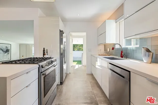 a kitchen with granite countertop a sink stove and refrigerator