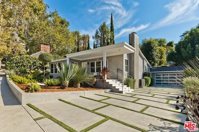 a front view of a house with a garden and plants
