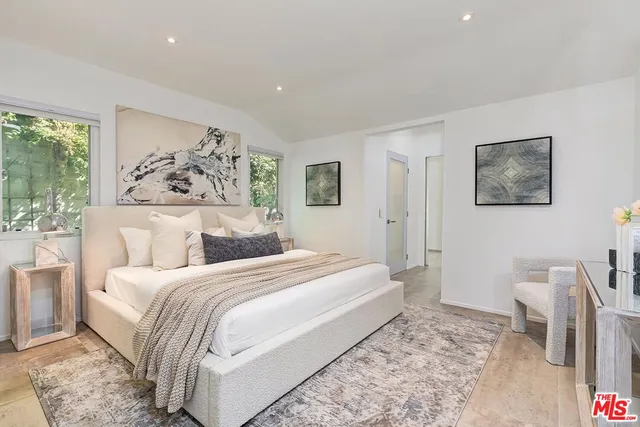 a bedroom with a large bed and a painting on the wall