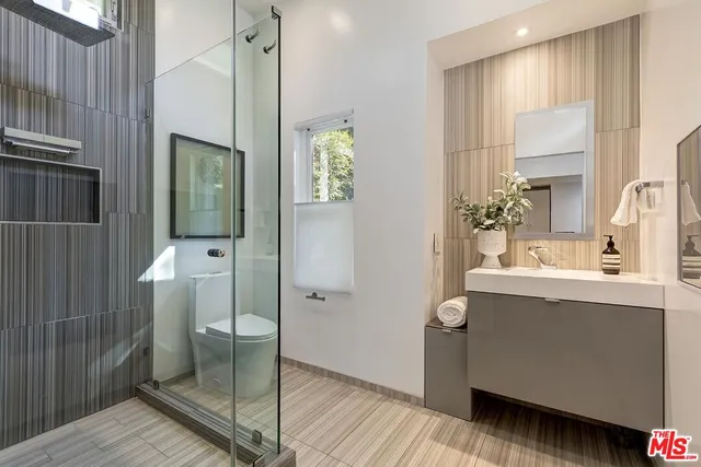 a bathroom with a sink mirror and shower
