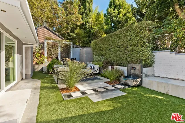 a view of a house with backyard sitting area and garden