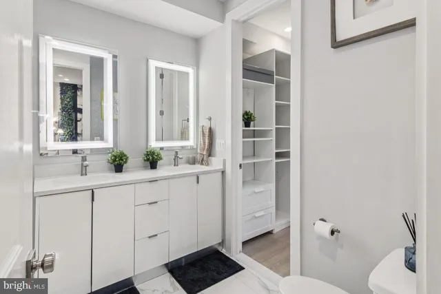 a bathroom with a sink and mirror with toilet