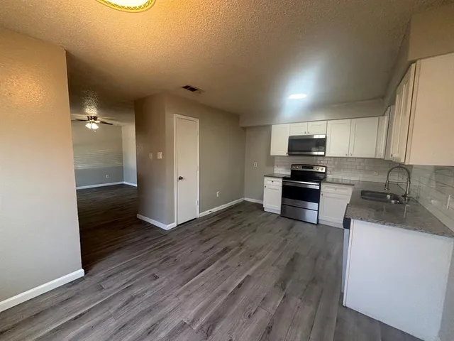 a kitchen with wooden floors and stainless steel appliances