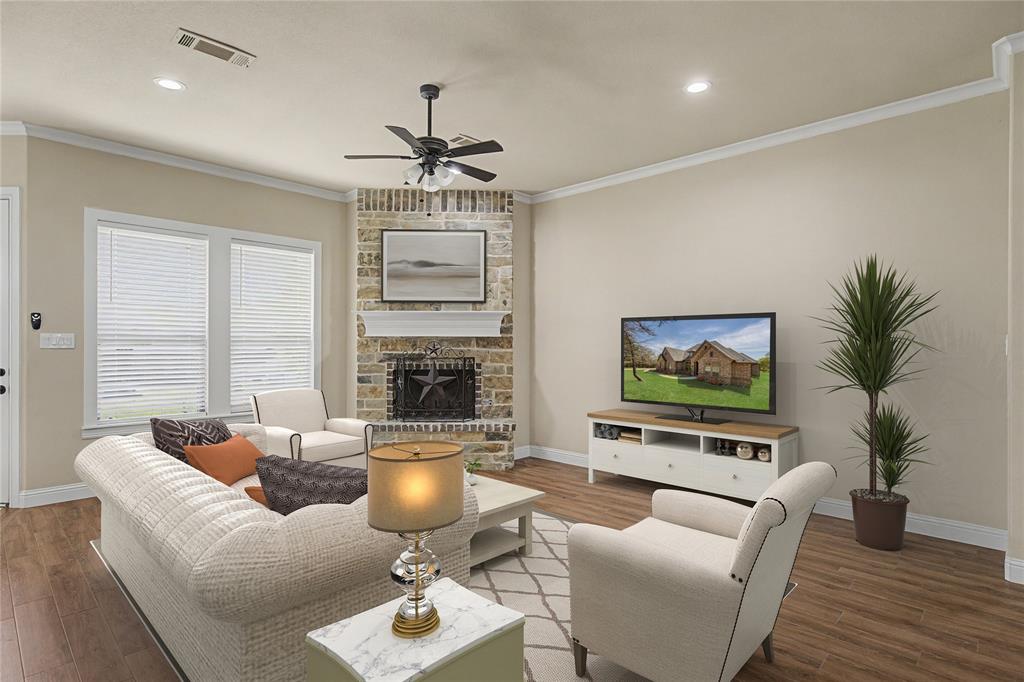143 Wrigley Drive Springtown, TX 76082 - Photo 5 of 40 Virtually Staged - Living area featuring a floor-to-ceiling stone fireplace with a white mantel, wood-finish flooring, and crown molding
