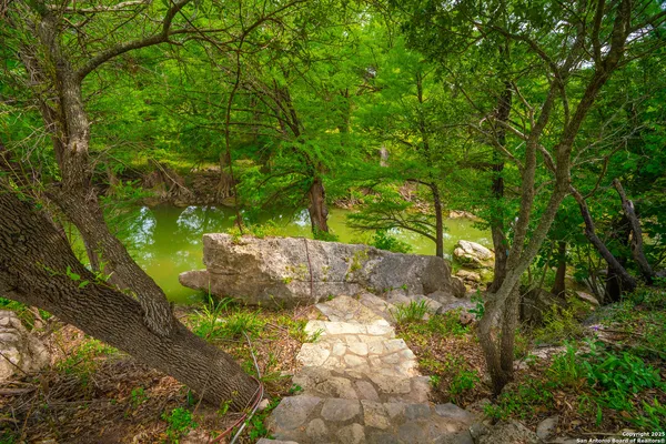 a backyard of a house with lots of green space and fountain