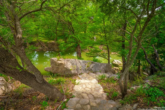 a backyard of a house with lots of green space and fountain