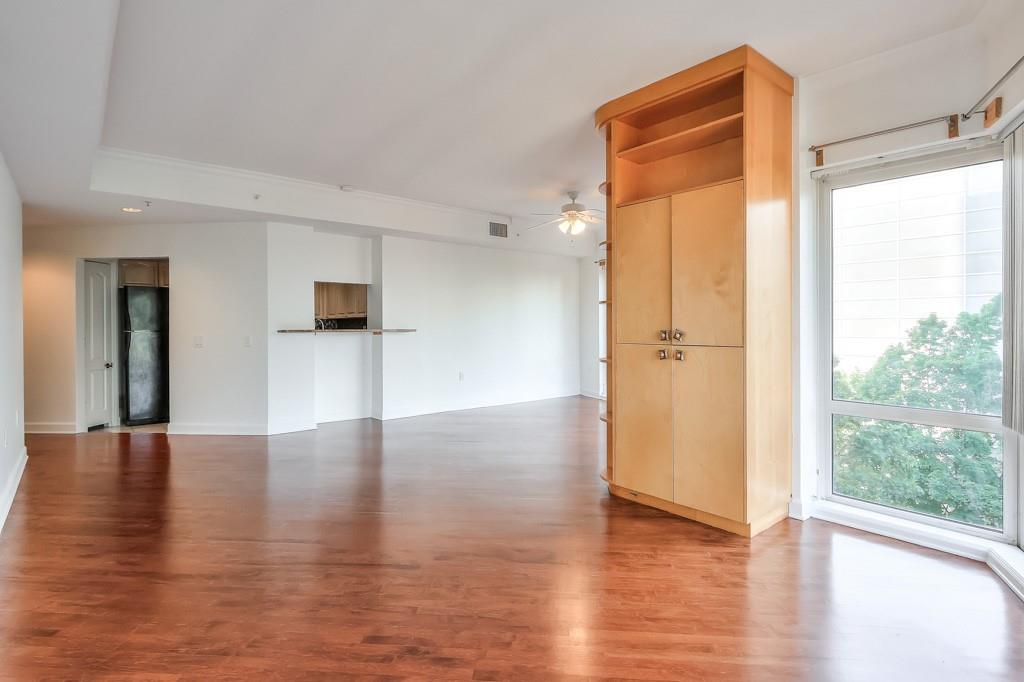 3475 Oak Valley Road Northeast, Unit 530 Atlanta, GA 30326 - Photo 16 of 37 a view of an empty room with wooden floor and a window