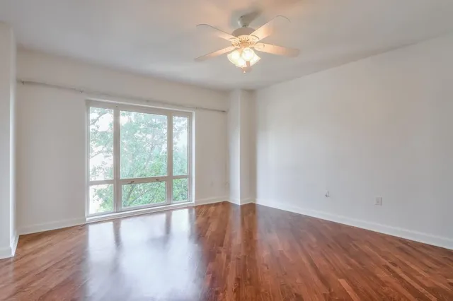 a view of an empty room with wooden floor