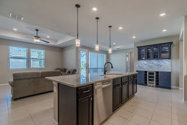 a kitchen with kitchen island granite countertop a sink a counter top space appliances and cabinets