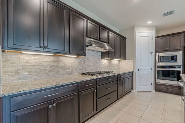 a kitchen with stainless steel appliances granite countertop a sink and a stove