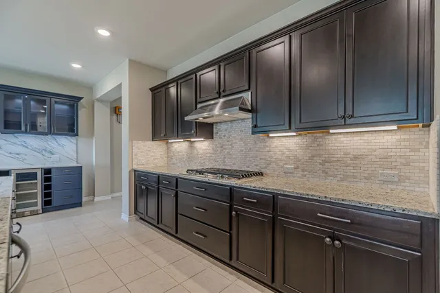 a kitchen with stainless steel appliances granite countertop wooden cabinets a stove top oven a sink and dishwasher