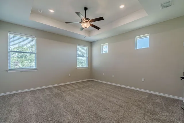an empty room with a ceiling fan and window