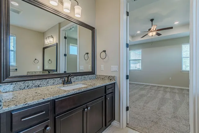 a bathroom with a granite countertop sink and a mirror