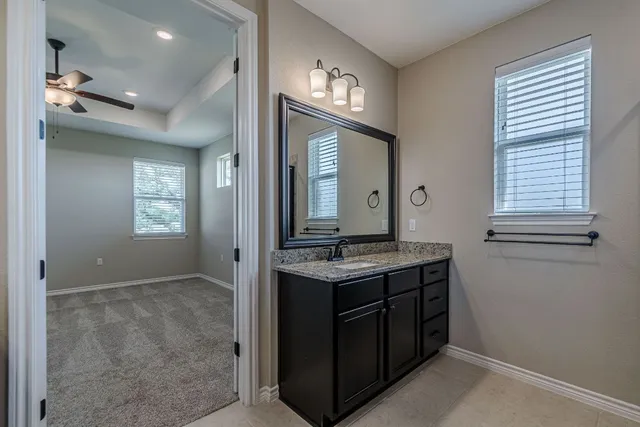 a bathroom with a granite countertop sink a large mirror and a vanity
