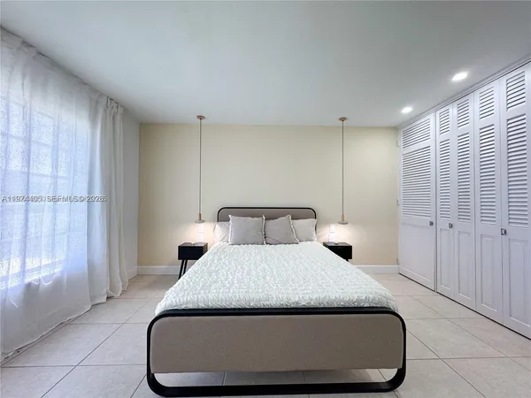 a bedroom with a large bed and a chandelier