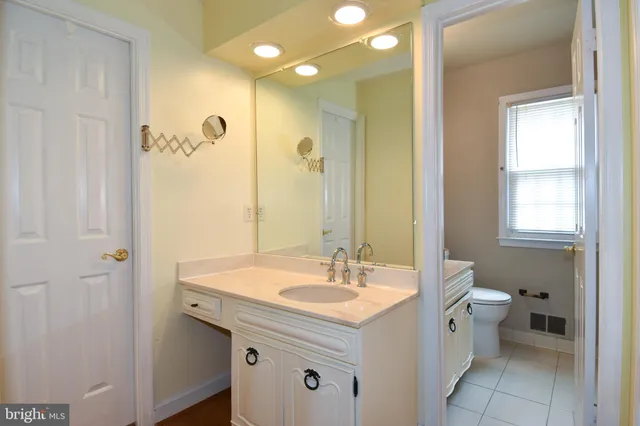 a bathroom with a sink mirror and a toilet