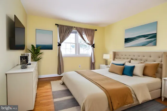 a bedroom with a bed and a flat tv screen on dresser