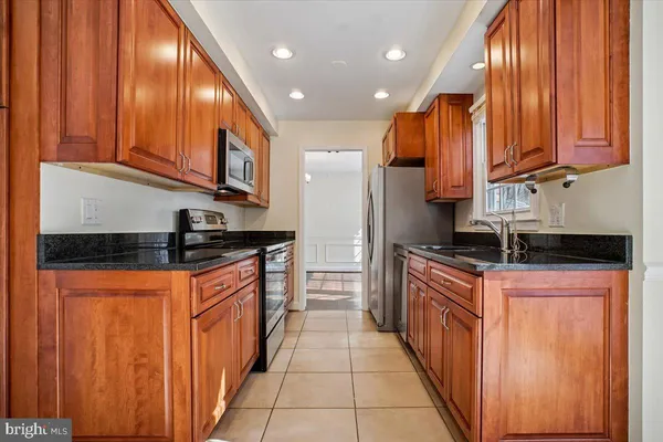 a kitchen with stainless steel appliances granite countertop wooden cabinets a sink and dishwasher
