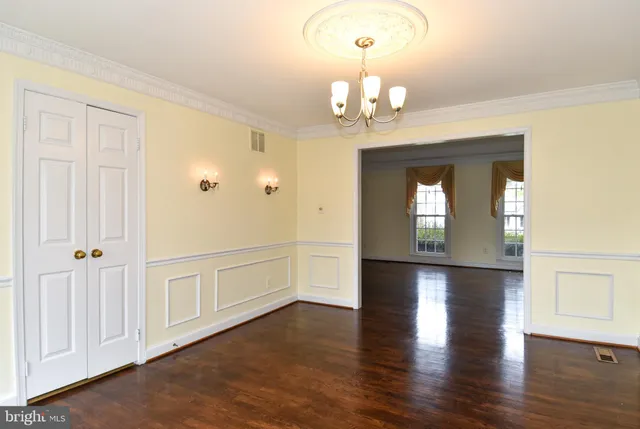 an empty room with wooden floor sink and cabinet