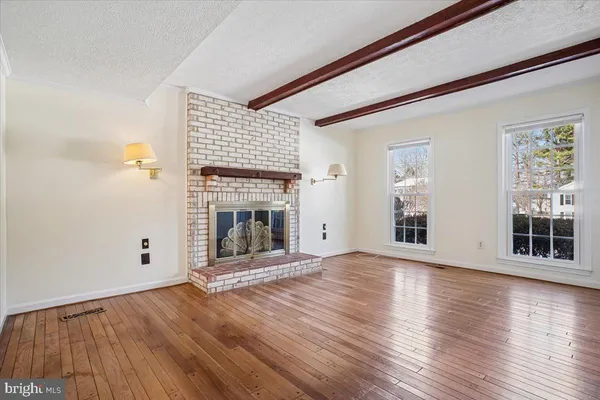 a view of a livingroom with wooden floor and a fireplace