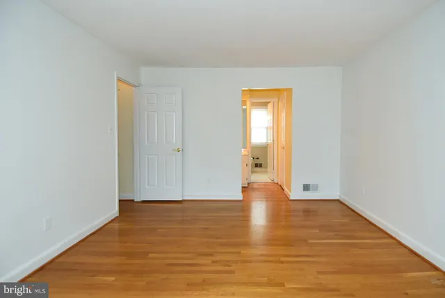 a view of an empty room with wooden floor