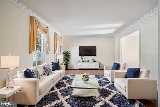 a living room with furniture a flat screen tv and a lamp