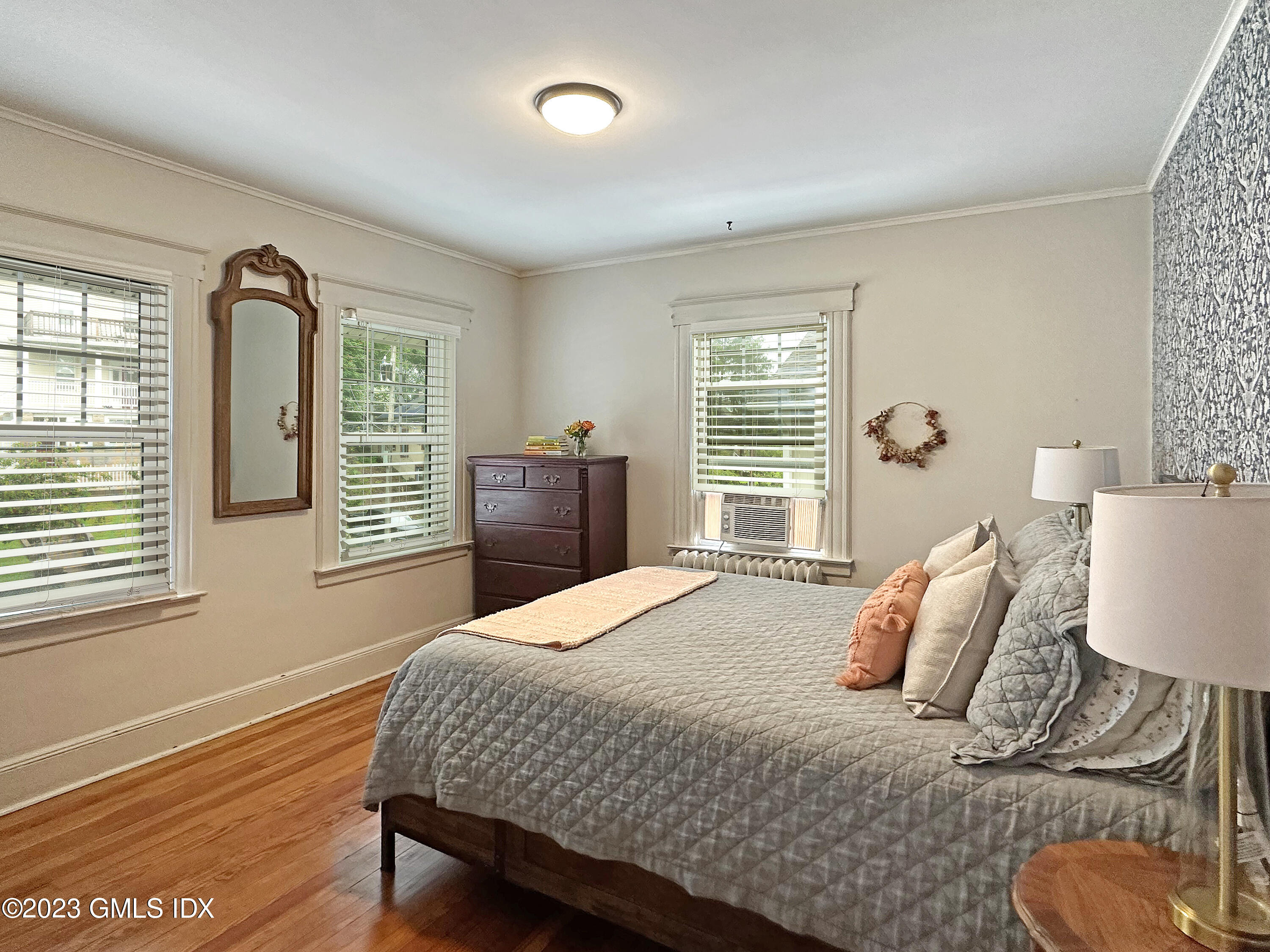 328 Delavan Avenue Greenwich, CT 06830 - Photo 13 of 25 a bedroom with a bed and dresser with wooden floor