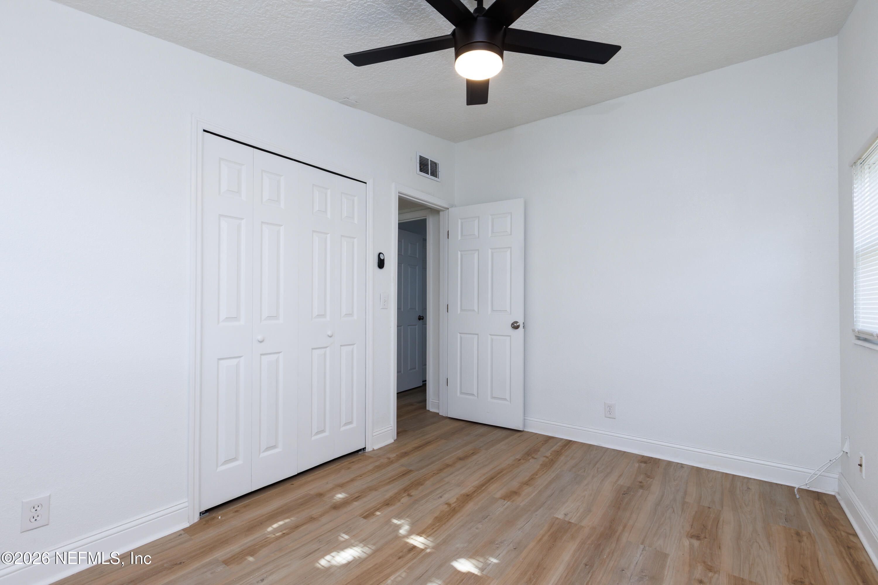 203 Rio Road Jacksonville, FL 32218 - Photo 15 of 27 an empty room with wooden floor and windows