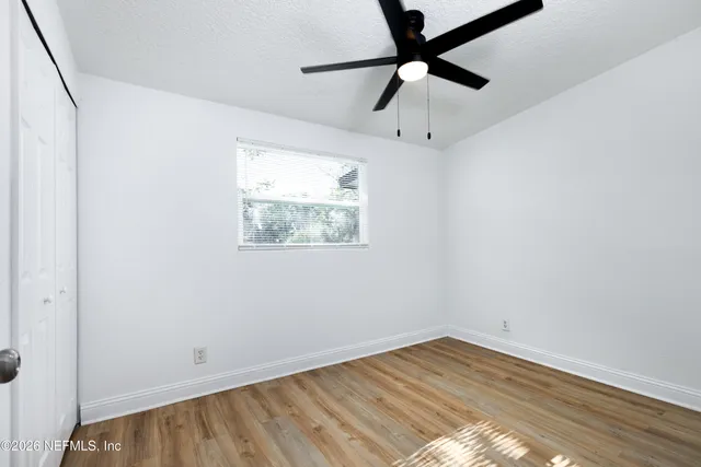 an empty room with wooden floor and windows