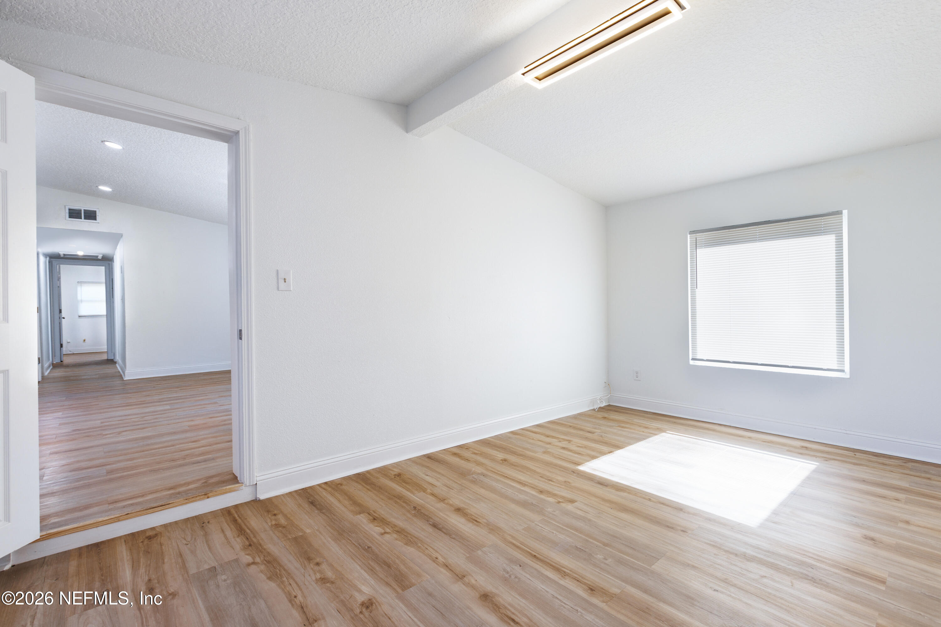 203 Rio Road Jacksonville, FL 32218 - Photo 17 of 27 an empty room with wooden floor and windows