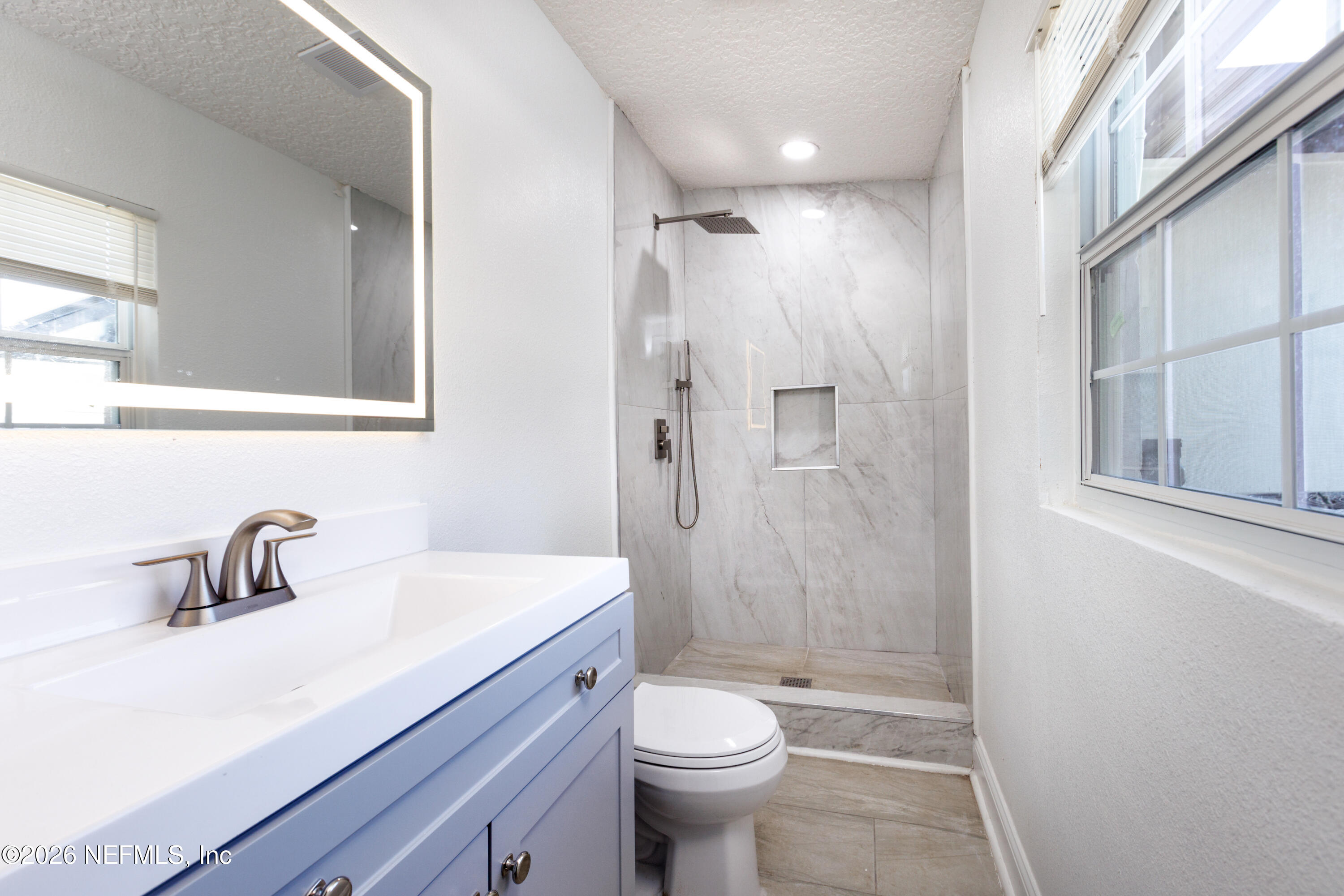 203 Rio Road Jacksonville, FL 32218 - Photo 18 of 24 a bathroom with a sink a toilet a shower and a mirror