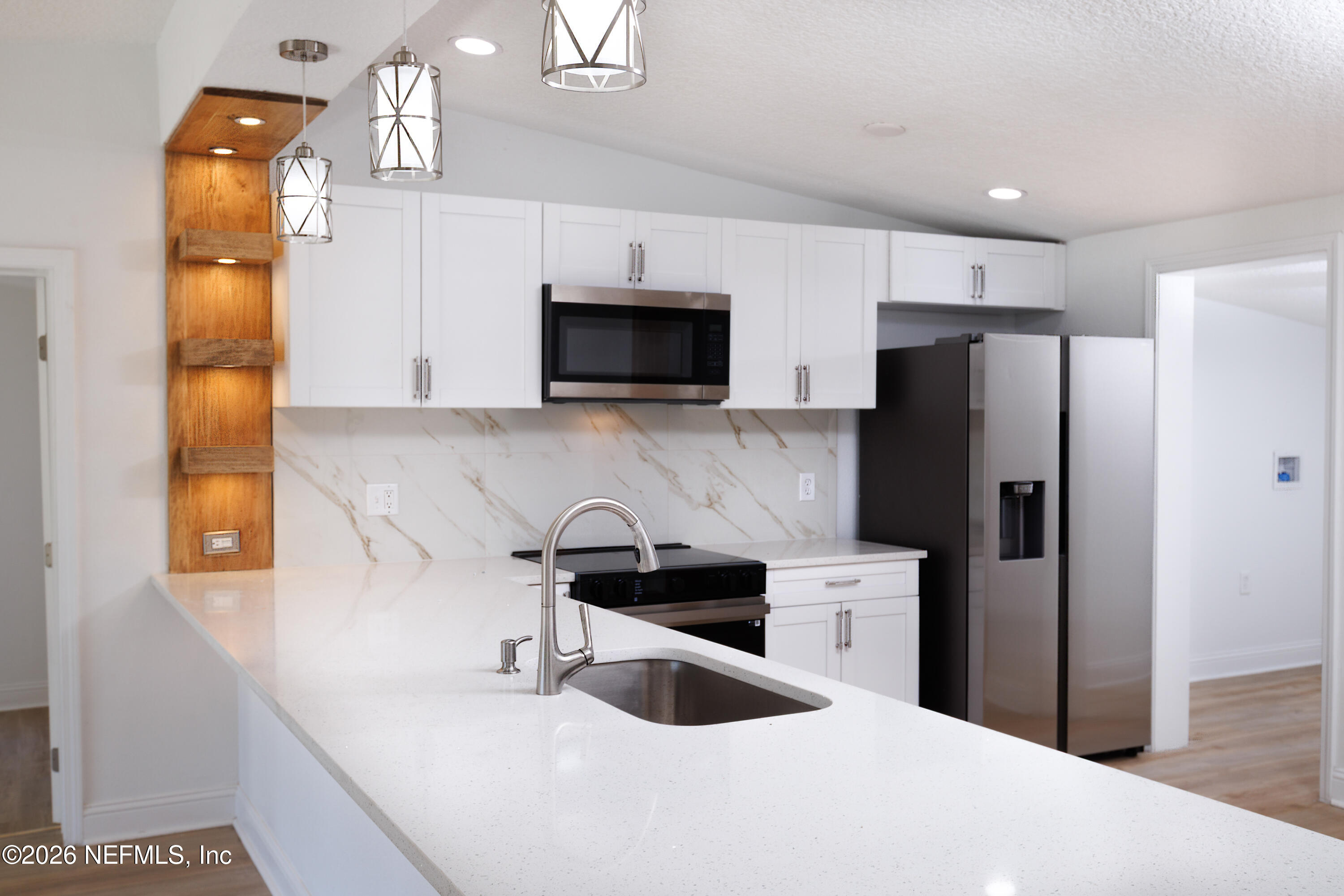 203 Rio Road Jacksonville, FL 32218 - Photo 6 of 24 a kitchen with stainless steel appliances a refrigerator sink and microwave