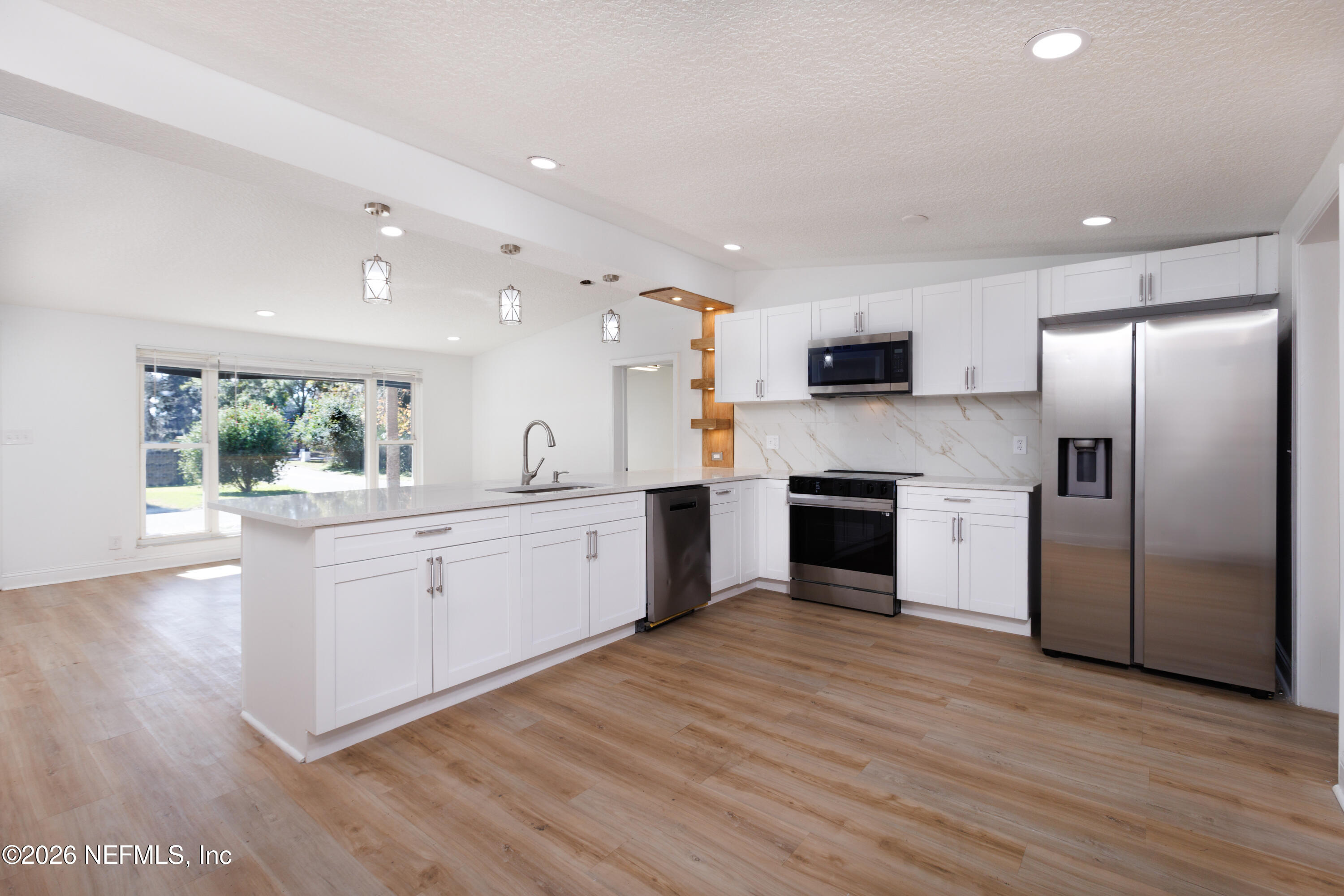 203 Rio Road Jacksonville, FL 32218 - Photo 8 of 27 a large kitchen with cabinets wooden floor and stainless steel appliances