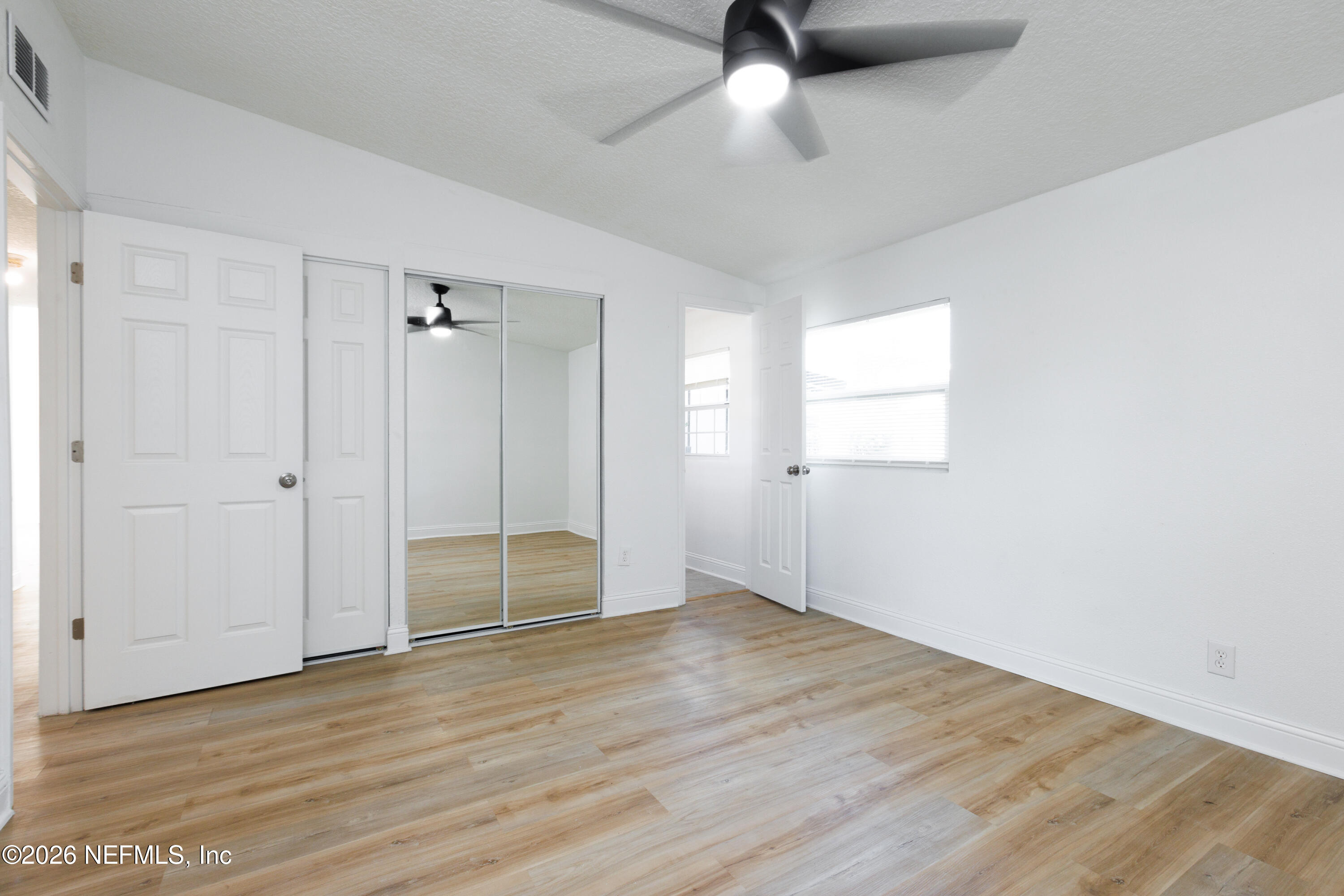 203 Rio Road Jacksonville, FL 32218 - Photo 9 of 24 an empty room with wooden floor cabinet and windows