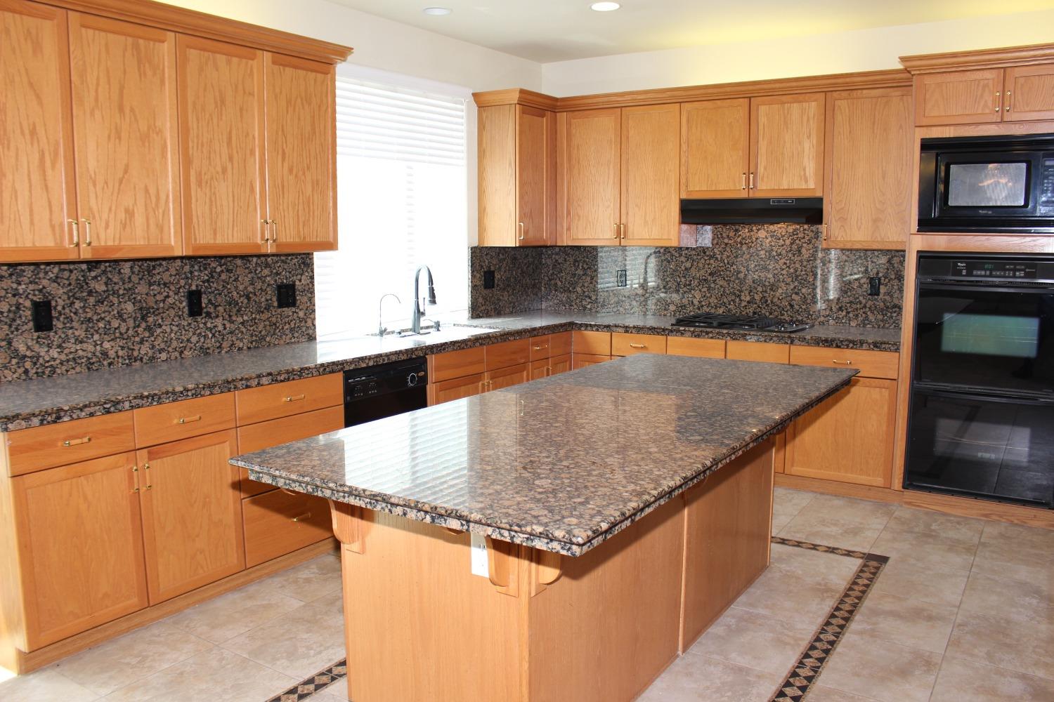 2478 Rall Avenue Clovis, CA 93611 - Photo 11 of 35 a kitchen with stainless steel appliances granite countertop a sink a stove and a microwave
