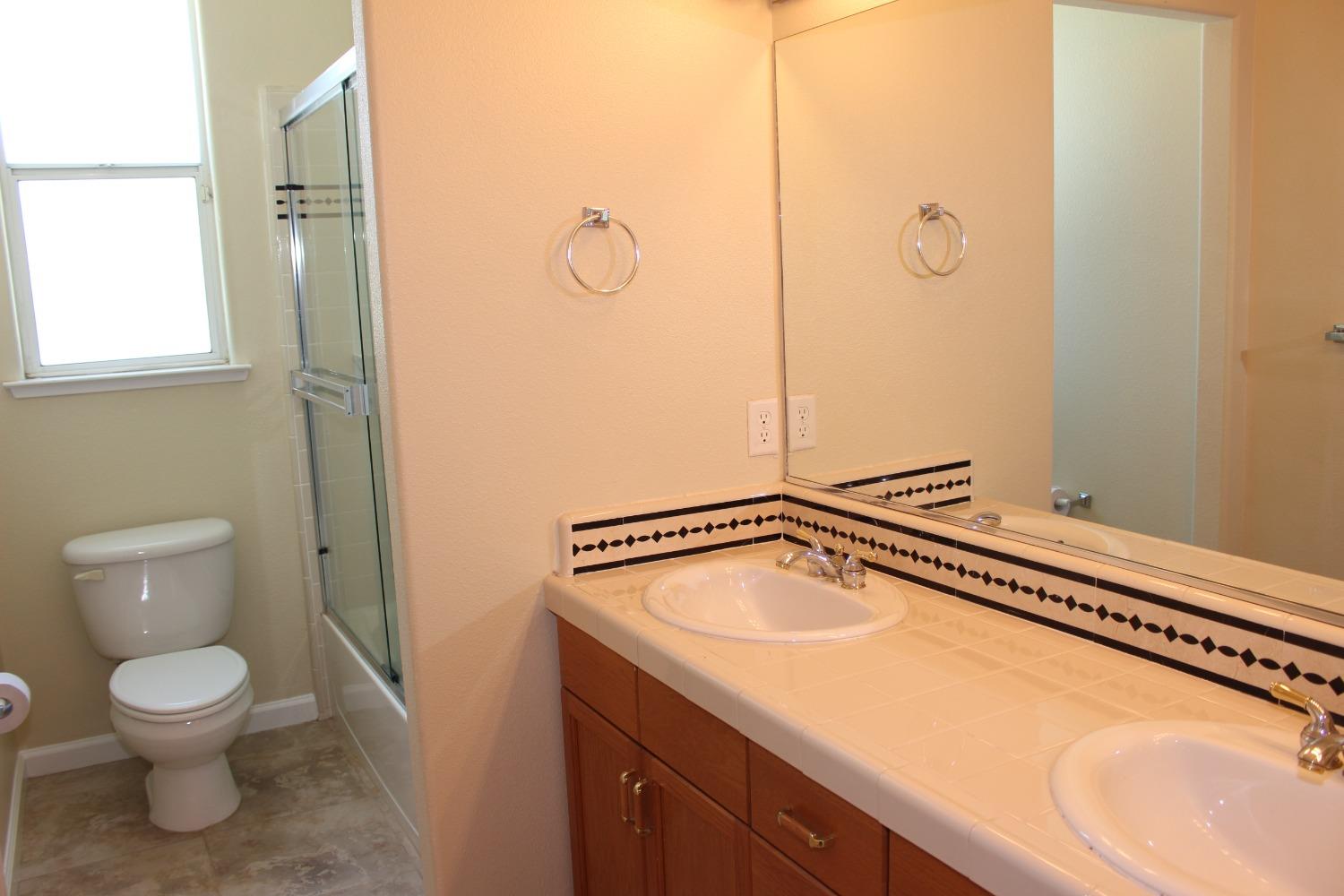 2478 Rall Avenue Clovis, CA 93611 - Photo 17 of 35 a bathroom with a granite countertop sink toilet and shower