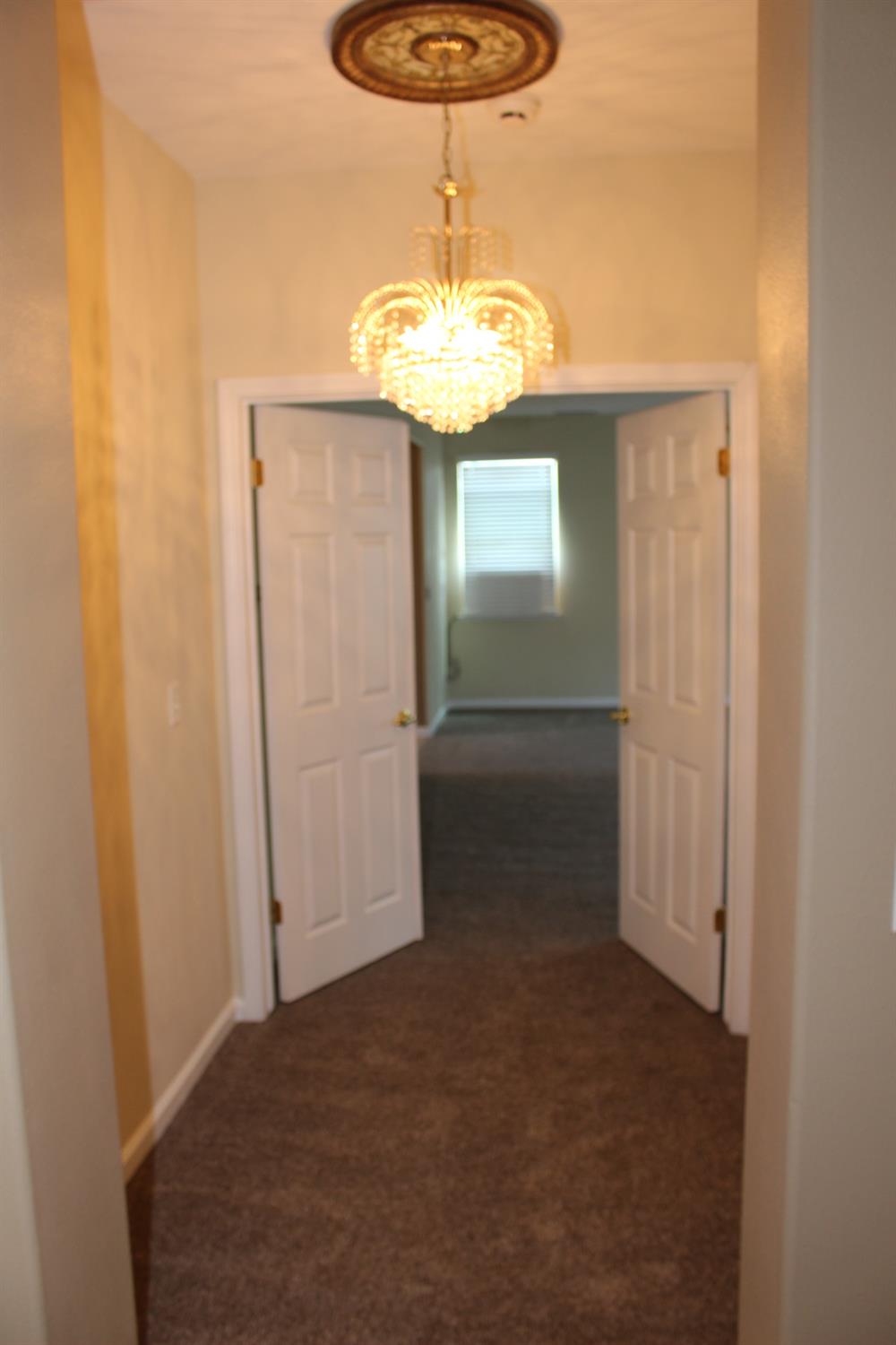 2478 Rall Avenue Clovis, CA 93611 - Photo 19 of 35 a view of a hallway with a chandelier fan
